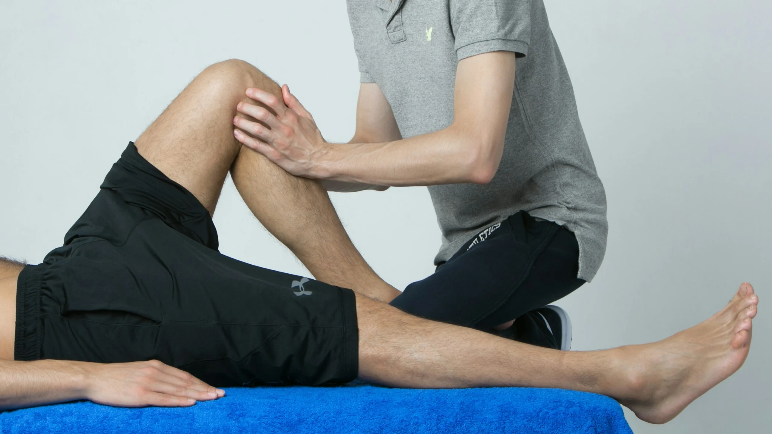 Physio therapist working on knee sports therapist working on patient's knee